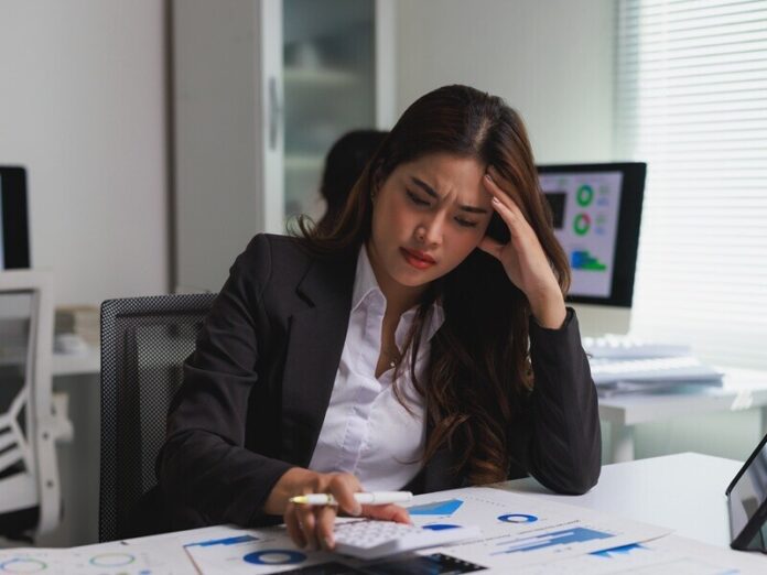 Stressed businesswoman calculating expenses facing financial problems How professional bookkeeping saves time and reduces stress